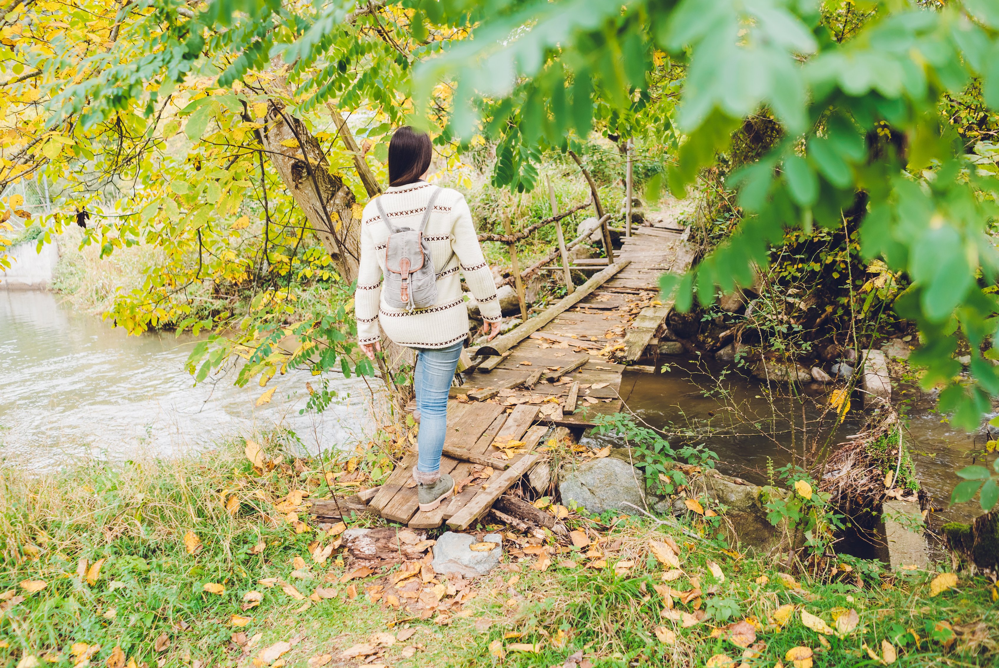 Woman crossing mountain bridge